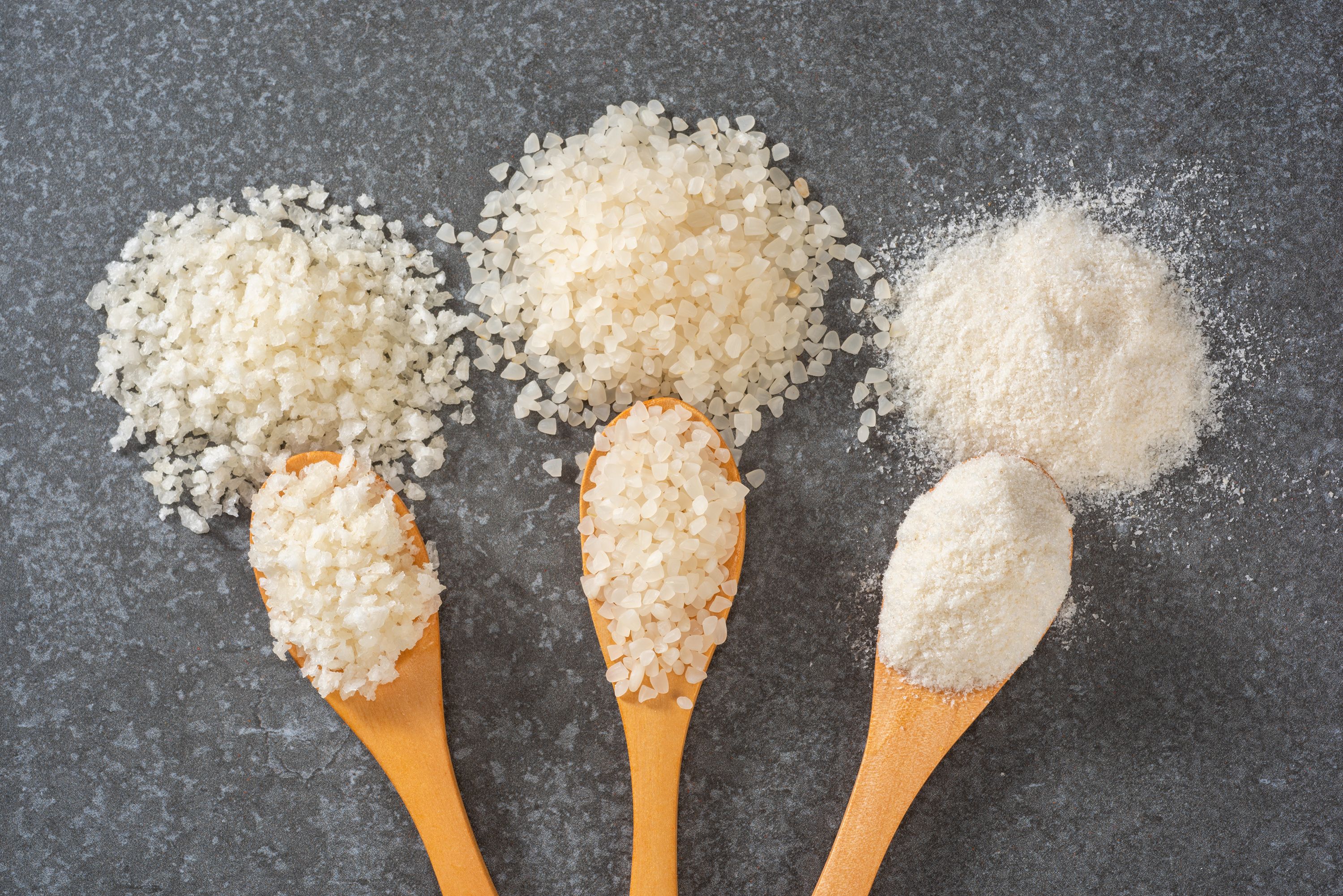 Arroz roto y molido sobre cucharas de madera