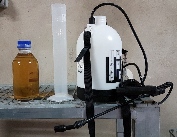 Material básico para la aplicación de un cóctel de fagos vía aerosol en una instalación ganadera; de izquierda a derecha: cóctel de fagos, probeta y pulverizador