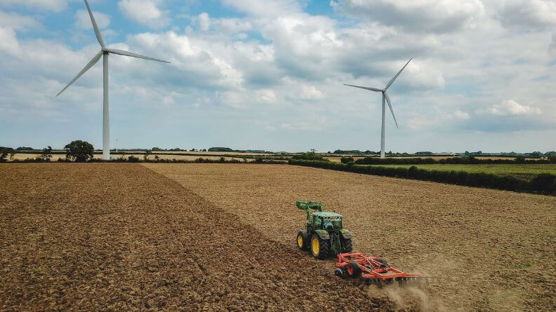 Tractor en un campo arando, políticas de precios en el sector agrario