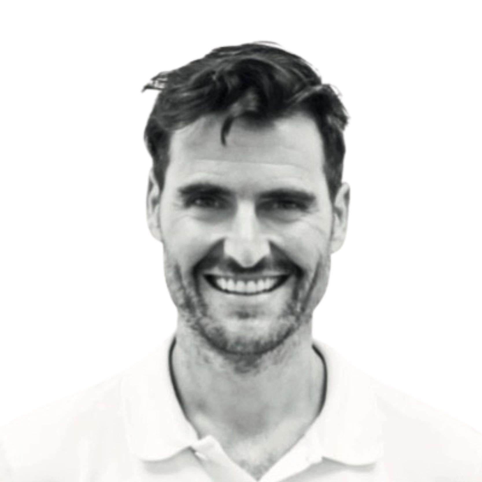 Hombre sonriente con barba y camisa blanca.