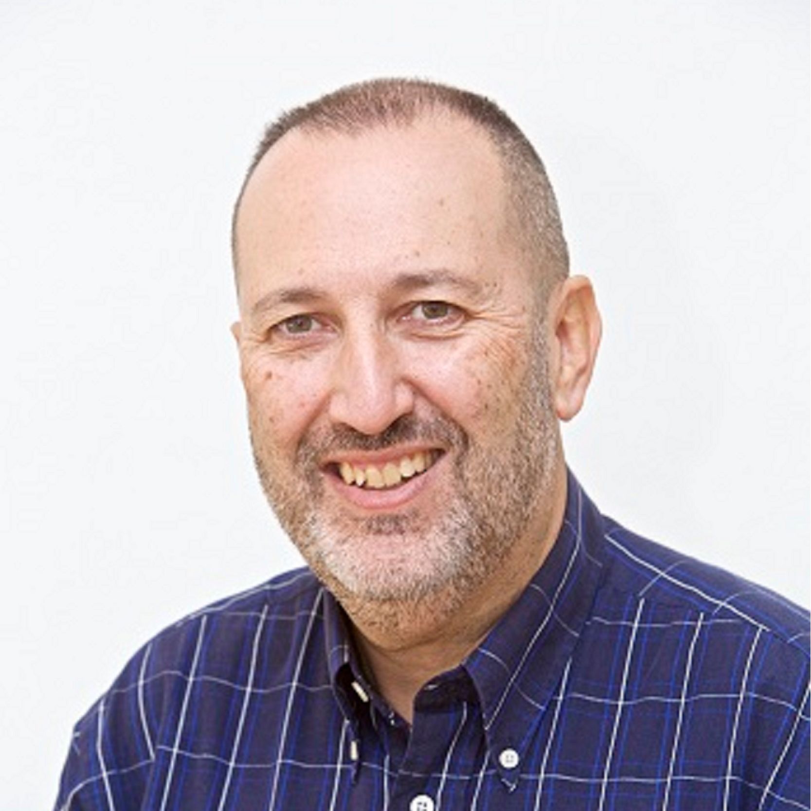 Hombre sonriente con camisa azul de cuadros y fondo blanco. Hombre sonriente con camisa azul de cuadros y fondo blanco.