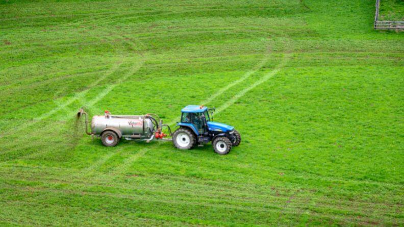 Tractor fertilizando el campo, comunicado sobre fertilizantes
