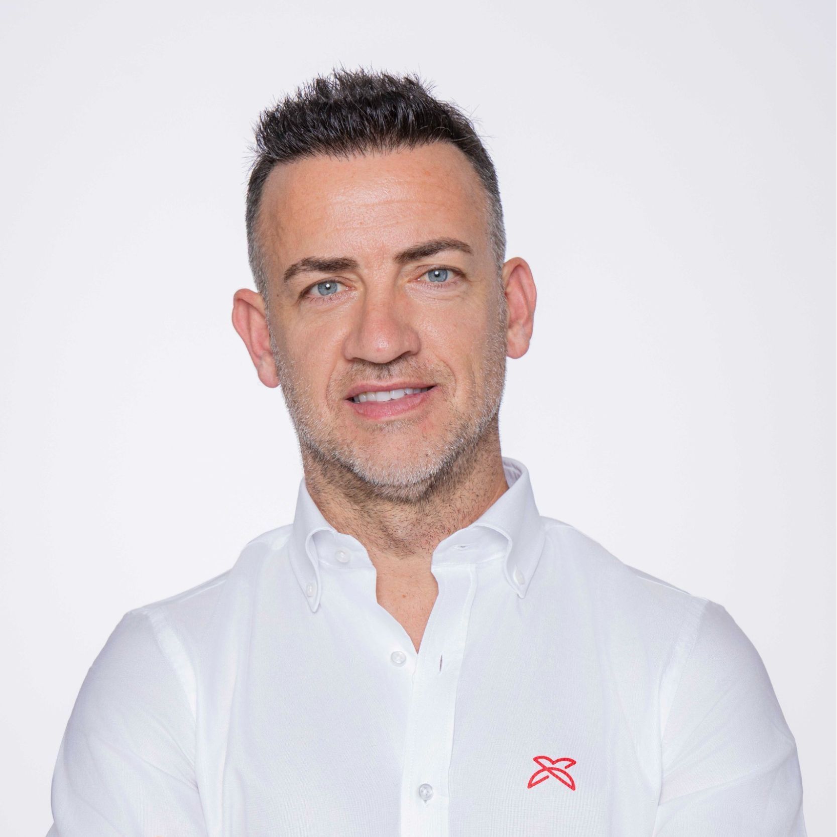 Hombre sonriente con camisa blanca.