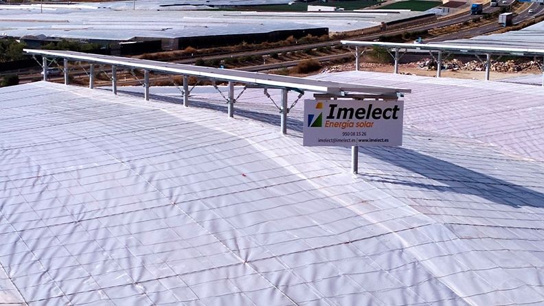 Detalle de la colocación de la línea de placas solares sobre la estructura del invernadero.