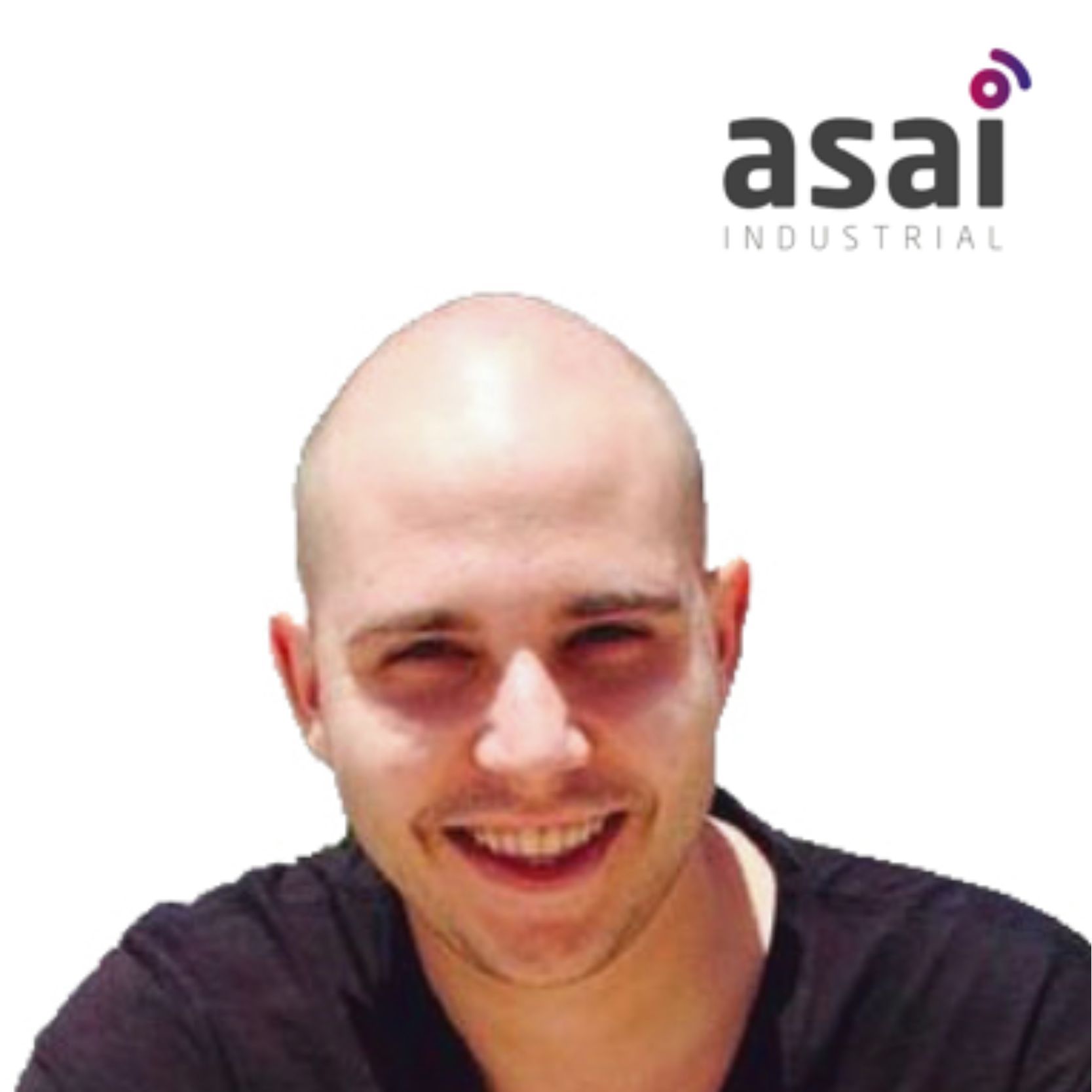 Un hombre sonriente con la cabeza rapada y una marca en la parte superior derecha.