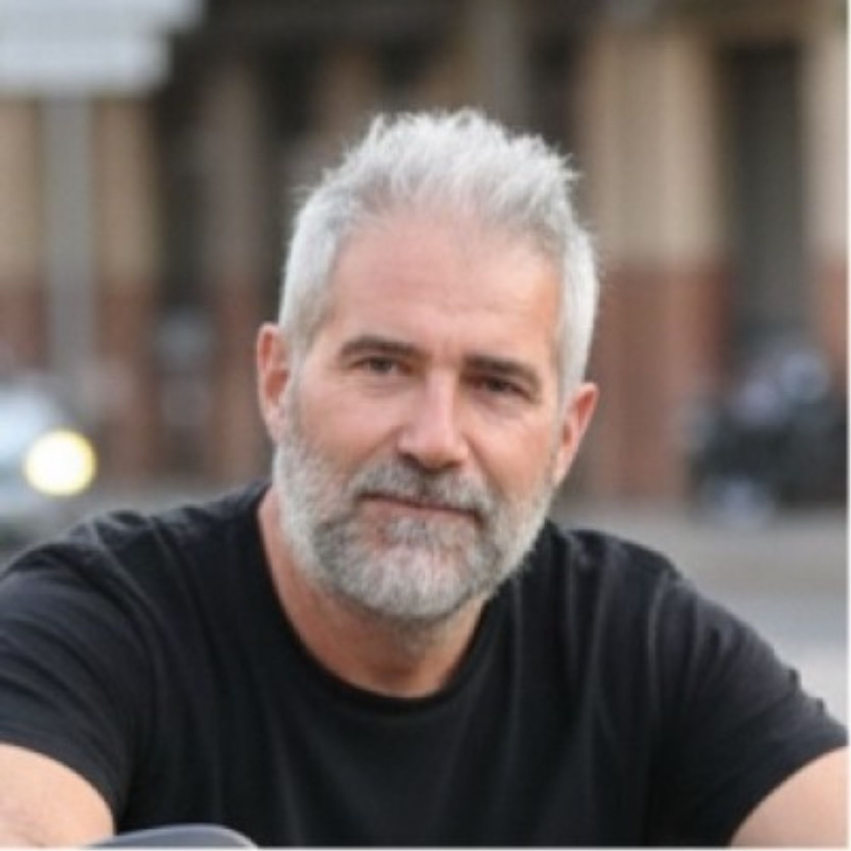 Un hombre de unos 50 años con cabello gris y barba corta.