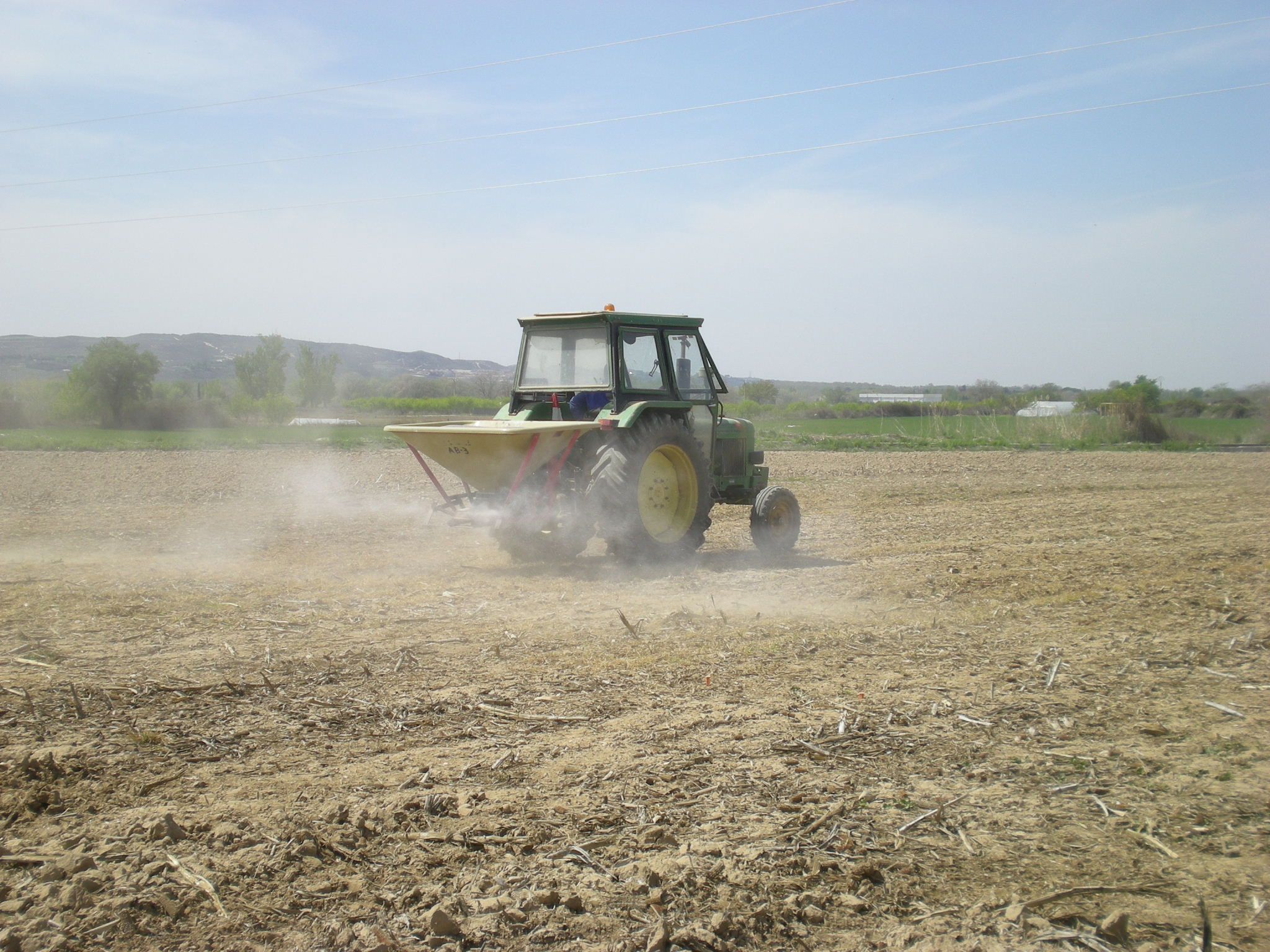 Tractor aplicando fertilizantes en un día de viento