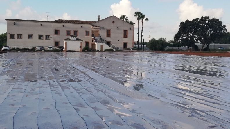 Una gran casa con estacionamiento cubierto con una lona de plástico.