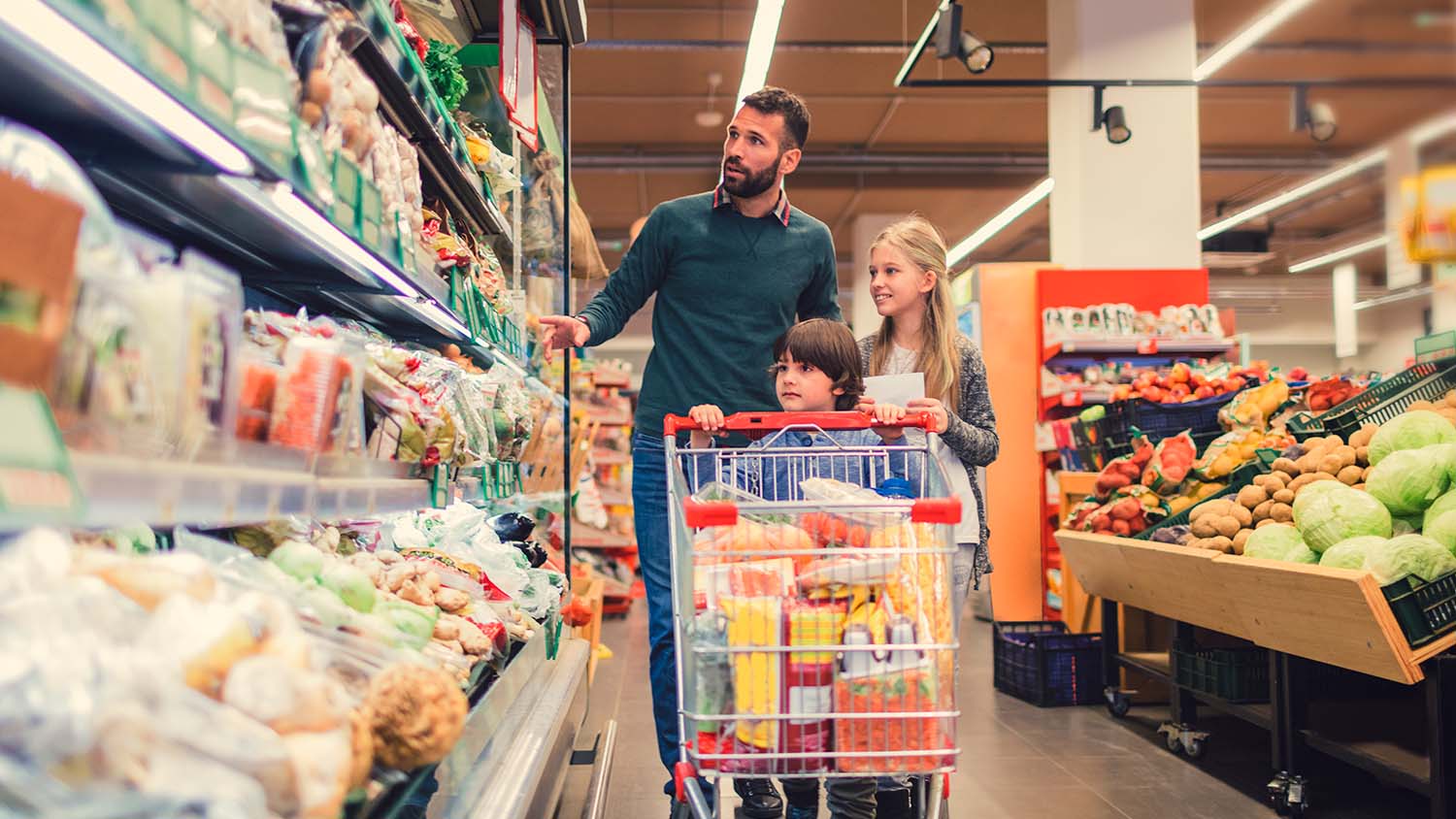 Padre con sus hijos comprando en un supermercado, indicativo de la situación del sector agroalimentario español en el contexto de Europa