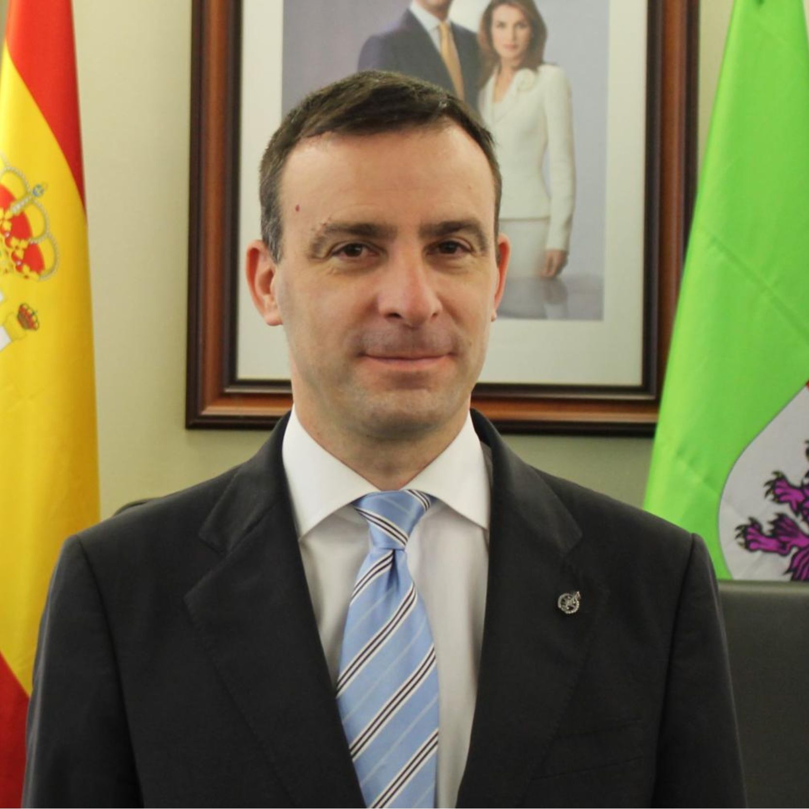 Hombre de mediana edad con traje y corbata delante de dos banderas. Hombre de mediana edad con traje y corbata delante de dos banderas.