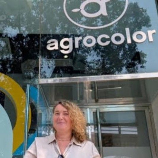 Empresaria frente a logo de Agrocolor.