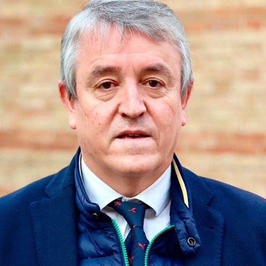 El hombre es de mediana edad con cabello gris, traje y corbata. El hombre es de mediana edad con cabello gris, traje y corbata.