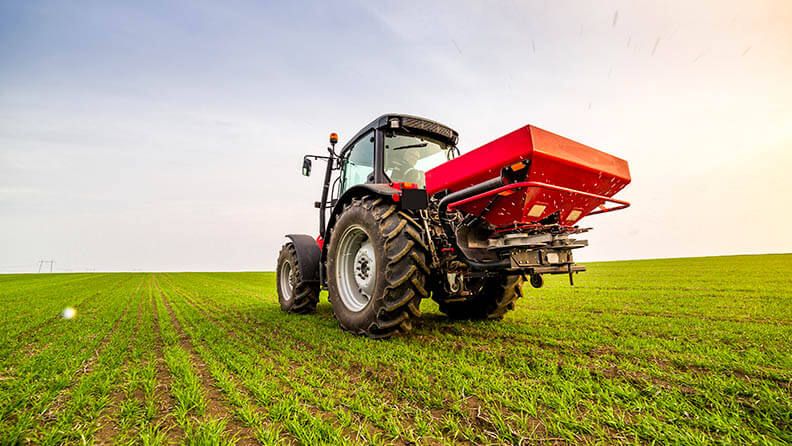 Tractor en el campo haciendo uso de la fertilización nitrogenada