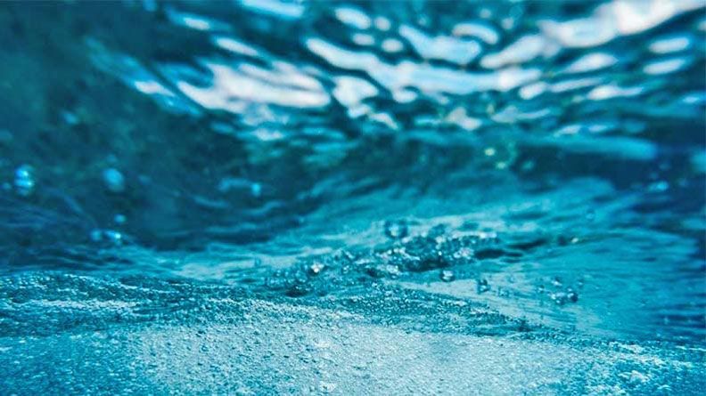 Torbellino de agua azul y cristalina, evoca la sostenibilidad del agua como necesidad