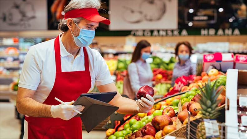 Sector Agroalimentario Español. Dependiente de supermercado con mascarilla