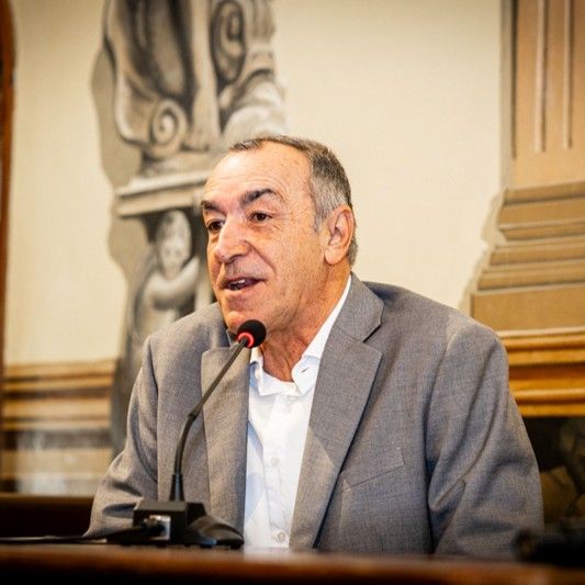 Hombre hablando en un micrófono en un entorno formal.