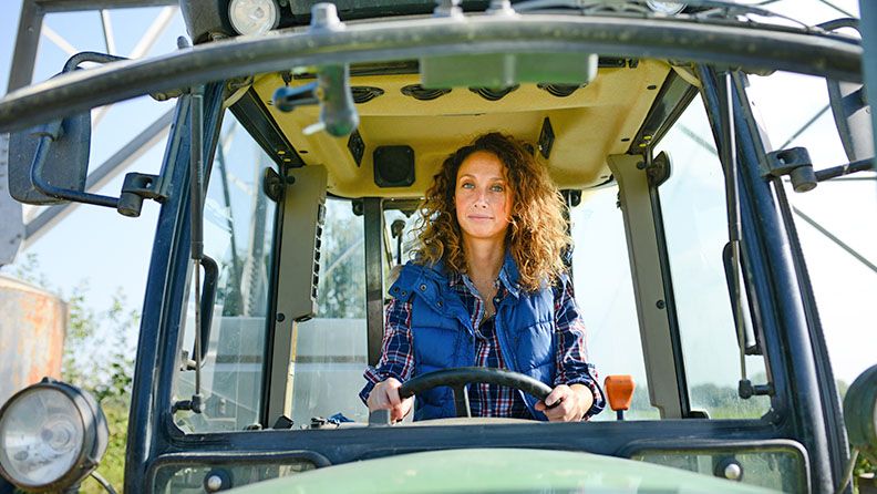 Mujer trabajando en el campo con un tractor