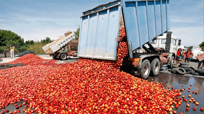 Camión volcando frutas y verduras. Foto: EFE
