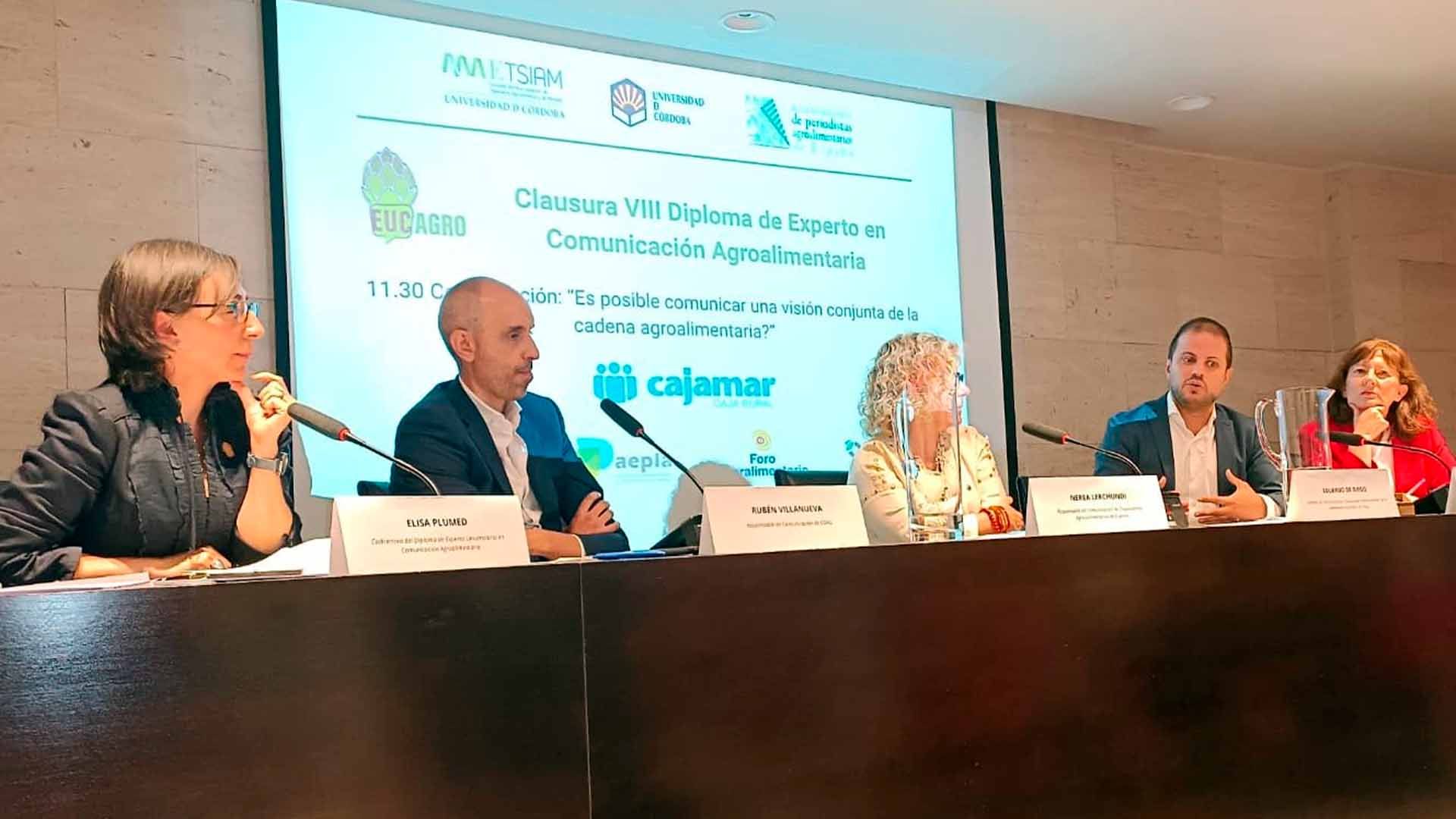 Tres personas en una mesa hablando.