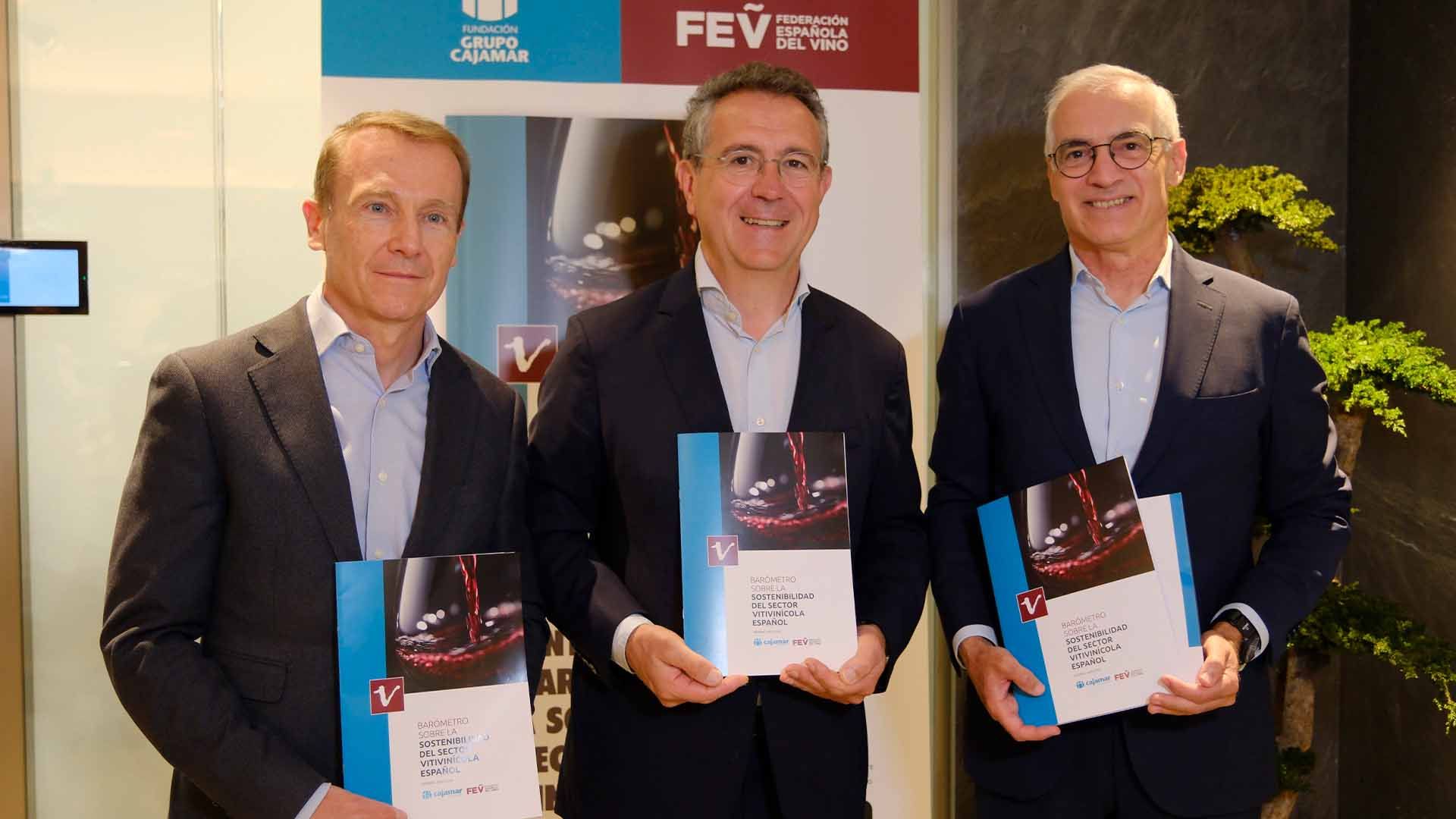 Tres hombres de negocios sonriendo y sosteniendo un documento sobre vino en español.