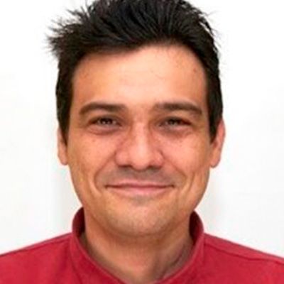 La imagen muestra a un hombre sonriente con cabello oscuro y camisa roja. La imagen muestra a un hombre sonriente con cabello oscuro y camisa roja.