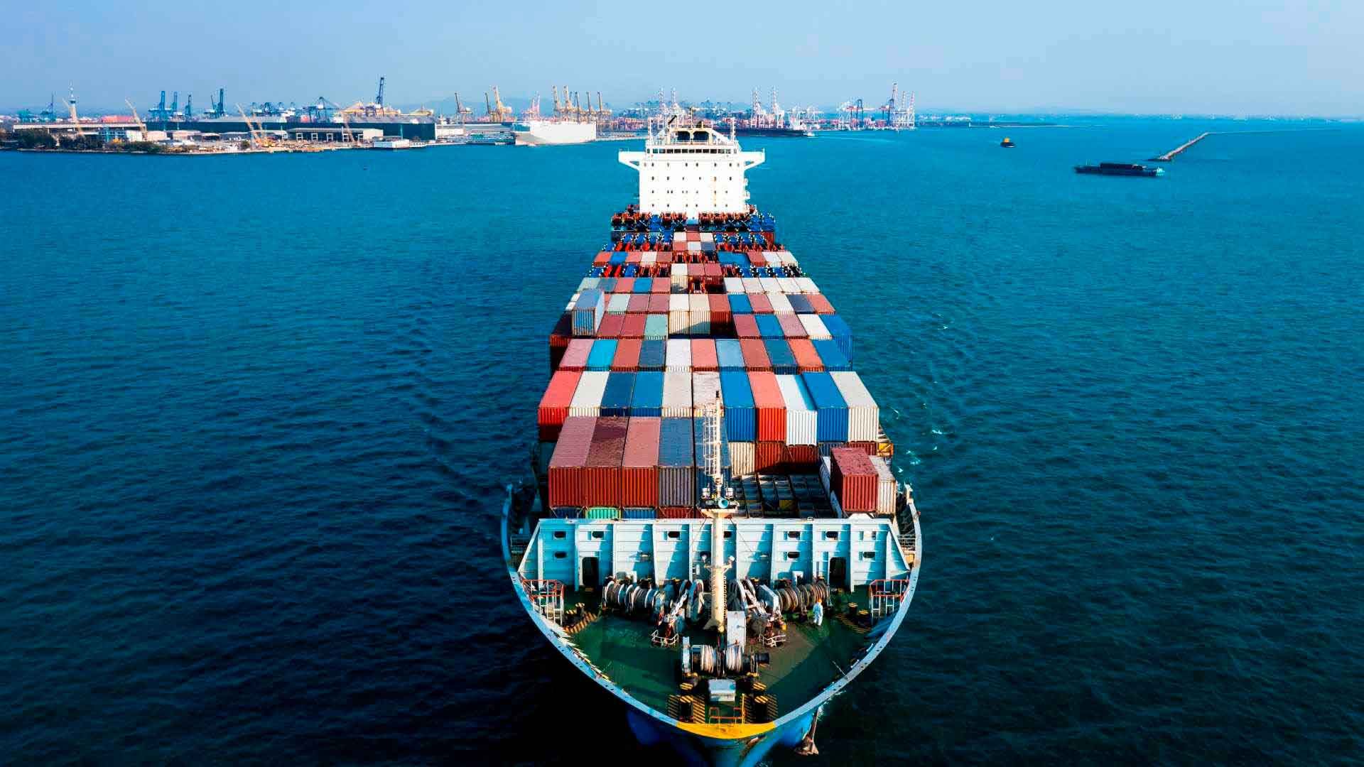 Barco de carga inicia viaje desde puerto.