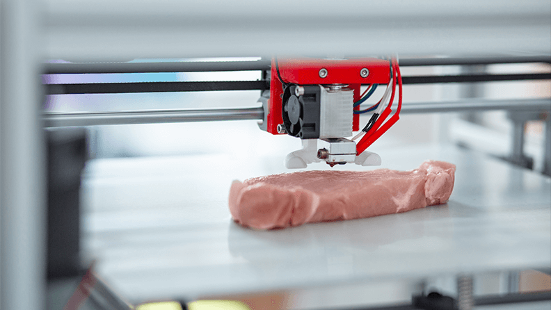 Primer plano de una impresora 3D recreando un trozo de carne