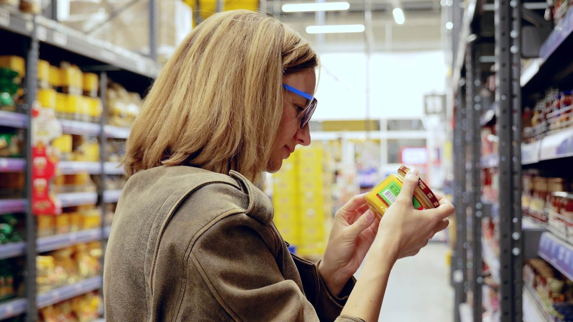 Una mujer revisa el etiquetado de un producto en el supermercado.