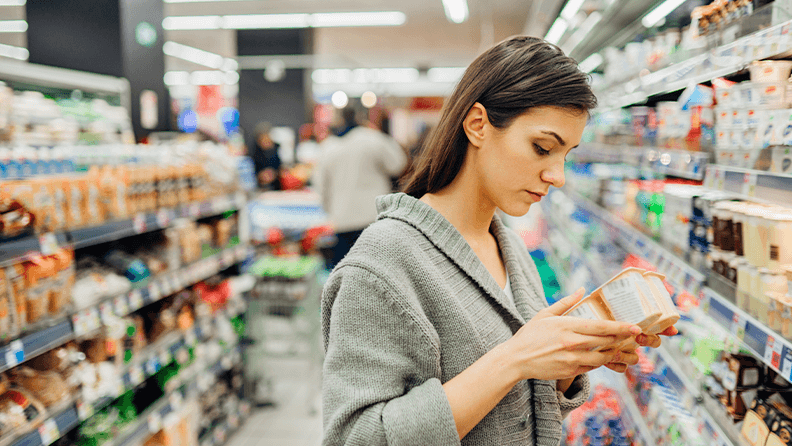 Mujer mira etiqueta en supermercado