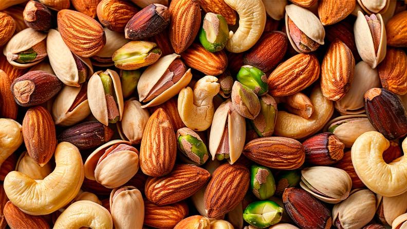 La imagen muestra una mezcla de frutos secos, incluyendo nueces y semillas.