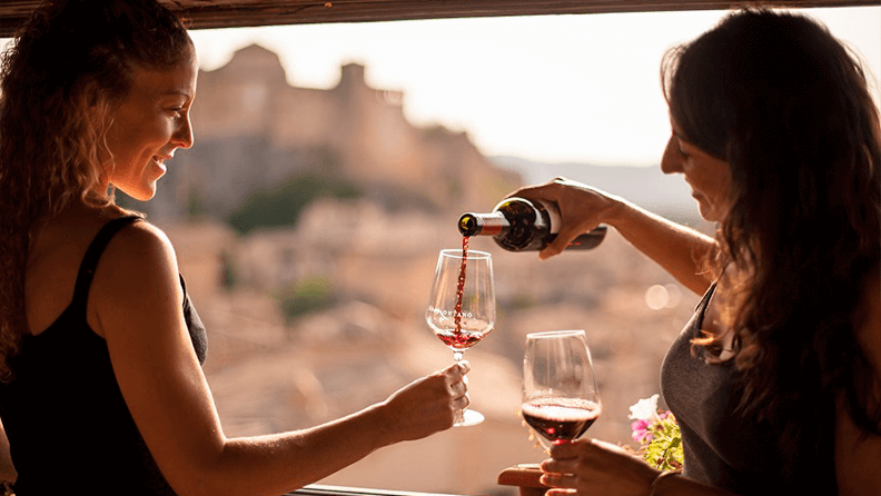 Dos mujeres comparten una botella de vino