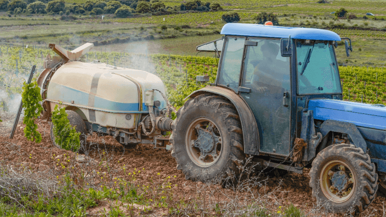 Un tractor trabaja en un viñedo.