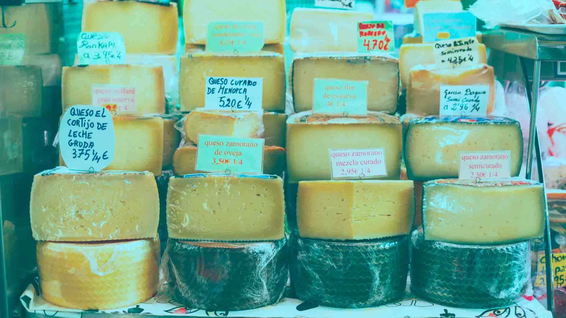 Quesos artesanales con precios en un mercado o tienda de productos locales.