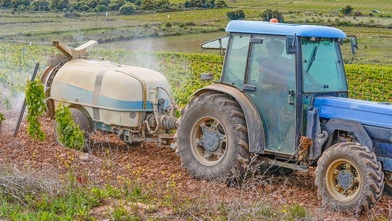 Tractor sulfatando los viñedos