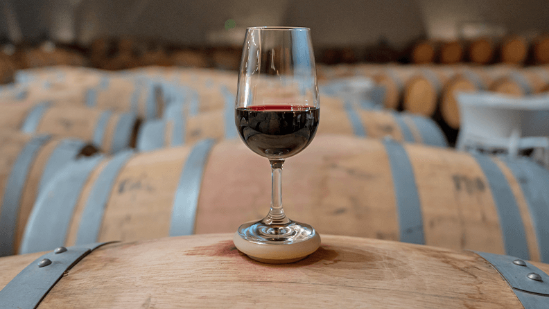 Copa de vino Rioja sobre barrica de roble
