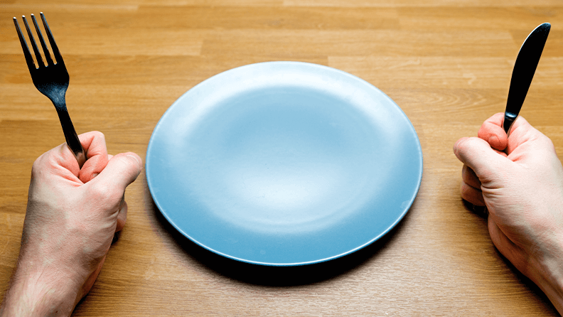 Comensal esperando con un plato vacío en la mesa