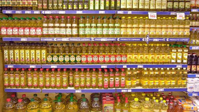 Lineal de supermercado con diferentes marcas de aceite de oliva y girasol español