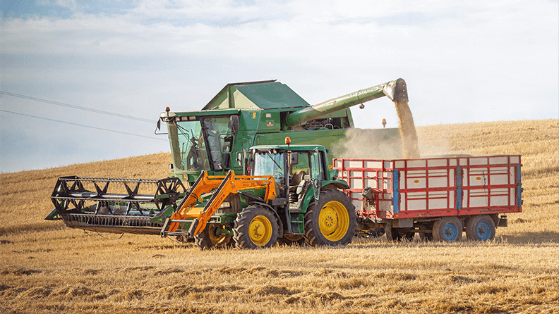 Una máquina segadora y un tractor con remolque en un cultivo de cereal en La Rioja. Efeagro/ Raquel Manzanares