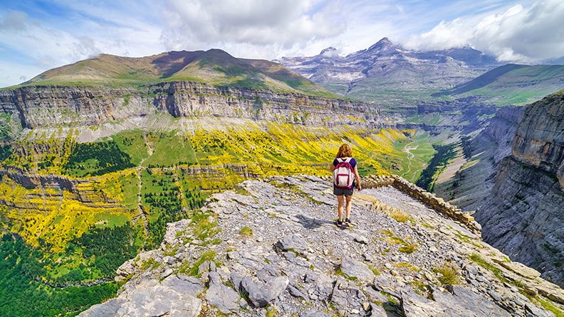 Mujer de senderismo por los picos de los Pirineos en el Valle de Ordesa, España.